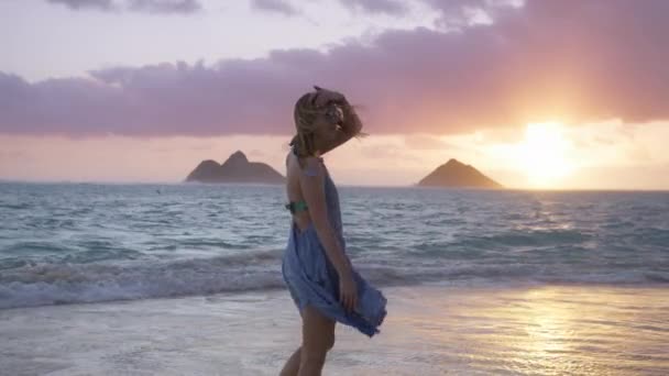 映画黄金の光ピンクの日の出で美しい手を振っドレスの女性 風光明媚なビーチの風景を楽しむスローモーション女性Recカメラ4K オアフ島の夏休みの女性観光客 ハワイ島Usa — ストック動画