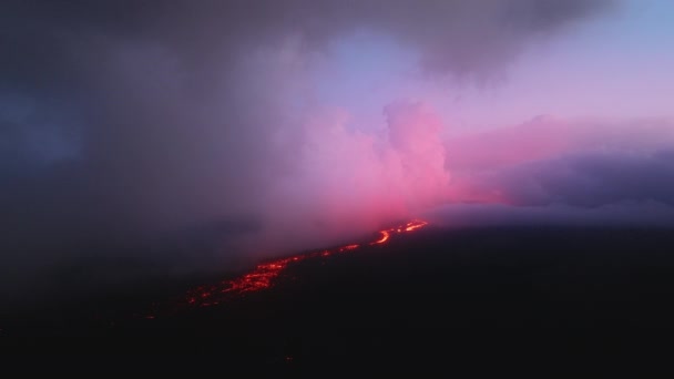 ハワイのビッグアイランドで噴火する火山の上でピンクの緋色の夕日または日の出の雲を息をのむ マウナロア山の紫色の雲の下の美しい熱い赤い溶岩の川の流れの上の空中 — ストック動画