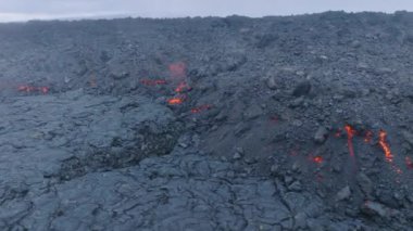 Kızgın siyah lav kayalarından oluşan bir hava. Mauna Loa Dağı 4K 'da volkan patlaması. Yokuştaki akarsulardan akan kırmızı erimiş lav. Hawaii 'deki Büyük Ada' da lav akışı, ABD hava çekimi