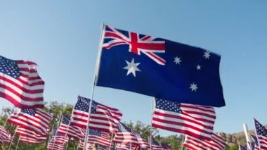 AUSTRALIA 'nın bayrağı rüzgarda dalgalanırken altın günbatımında birçok Amerikan bayrağı hareket halindedir. Ulusal AUSTRALIA bayrağı bağımsızlığı görselleştirme, mali ekonomi iş ortaklığı