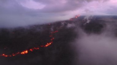 Sinematik çekim dumanı, tropik Hawaii Büyük Adası 4K 'da siyah donmuş lav tarlasının üzerinde güzel bir şekilde buharlaşıyor. Gökyüzünü kaplayan mor eflatun bulutlar Pembe günbatımında destansı sıcak kırmızı lav akıntısı