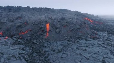 Siyah kömürde dumanla uçuşan ve donan kızıl lav dronunun inanılmaz hava görüntüsü. Pasifik Okyanusu 'ndaki Hawaii Adası' nda aktif dumanlı yüzey volkanı.