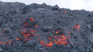 Hawaii, ABD 'deki Big Island' da lav akışı akıllı telefon kamerasıyla çekildi. Mauna Loa dağında volkan patlaması. Akan lav ve siyah kayalar. Yamaçtaki akarsulardan akan erimiş lav kraterinden akıyor.