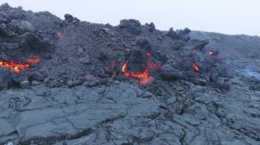 Mauna Loa dağında volkan patlaması. Akan lav ve siyah kayalar. Yokuştaki akarsulardan akan kırmızı erimiş lav. Hawaii, ABD 'deki Büyük Ada' da hava akımı insansız hava aracı ile vuruldu.
