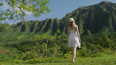 Mutlu otantik kız, tropikal Hawaii doğa manzarası 4K 'de dönüyor. Oahu bahçesinde tasasız genç bir kadın, kollarını kaldırıyor ve sinemanın yeşil orman arka planında dönüyor.