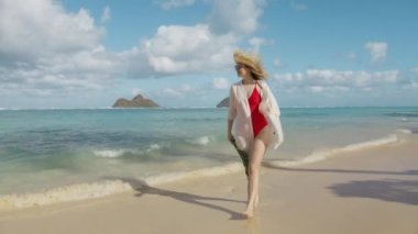 Oahu Adası 'nda tatil yapan Lanikai sahilinde tatil yapan bir kadın. Büyük yeşil yapraklı, saman şapkalı bir kız otel 4K 'de lüks bir yolculukta. Gezgin nüfuzlu kişi ünlü Hawaii 'ye gidiyor.