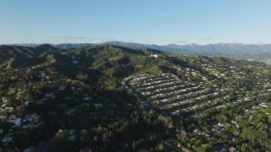 Los Angeles, Kaliforniya 'nın Los Feliz bölgesindeki Hollywood Hills' teki konakların insansız hava aracı görüntüleri. Hollywood Hills 'teki Griffith Gözlemevi parkındaki pahalı evlerle Los Angeles sokaklarının manzaralı görüntüsü.