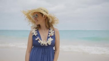 Okyanus manzaralı tropikal plajda duran mutlu romantik kadının açık hava portresi. Moda tarzında ve hasır şapkalı gülen kız. Seyahat tatili, Hawaii yaz tatili