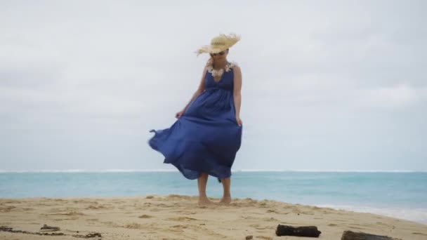 งสาวในช ดชายหาด Boho Maxi และหมวกฟางใหญ าและหม นรอบ บนชายหาดทราย Teal มหาสม — วีดีโอสต็อก