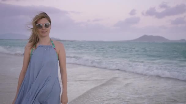 美丽的女孩喜欢早上在夏威夷海滩 欧胡岛海滨 年轻女子戴着太阳镜 迎风迎风而上 无忧无虑的美国女人 带着柔和的乳白色背景 与大海一起微笑 — 图库视频影像