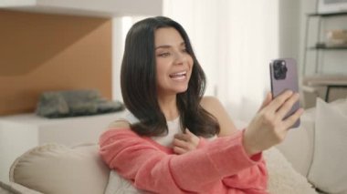 Kocasıyla, erkek arkadaşıyla ya da akrabalarıyla selfie ya da video görüşmesi yapan mutlu, zarif bir kadının sahnesi. Modern teknoloji kavramı, aile yavaş çekim 4K ile kablosuz bağlantı
