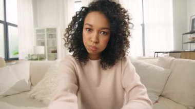 Tartışmayı kanıtlamak için kameraya el sallayan kıvırcık saçlı Afro-Amerikan blog yazarı kız. Aktif renkli kadın akıllı telefon özçekimi ve görüntülü sohbet konferansı kullanarak anlaşmazlık gösteriyor.