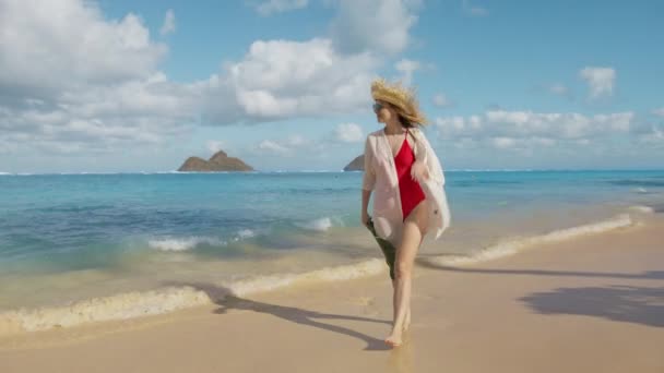 オアフ島の休日のパラダイスLanikaiビーチでの休暇の女性 リゾートホテル4Kの豪華な旅行で巨大な緑の葉を持つわらの帽子の女の子 有名なハワイの目的地を訪れる旅行者のインフルエンサー — ストック動画