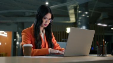 Ofiste e-posta yazan gözlüklü zeki bir kadın. Dolly, özgüvenli odaklı Asyalı esmer kadının laptopta bir e-posta yazması, bilgisayarı kapatması, işi bitirip ayrılması.