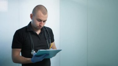 Veteriner kliniğindeki kağıt panoya not alan olumlu bir veteriner portresi. Veterinerlik tıbbi iş konsepti kopya geçmişi. Zeki profesyonel erkek doktor. Hayvan bakımı konsepti