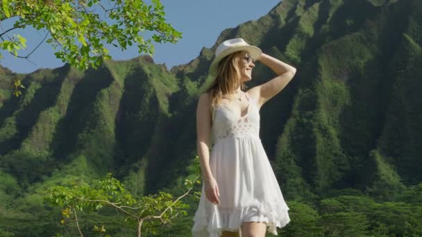 ハワイの庭を歩く女の子の観光客 女性は熱帯の風景を賞賛します アクティブなファッションブロガー観光ライフスタイル 緑のジャングルの山の背景に若い女性旅行者 夏の自然 ハワイの風景 — ストック動画