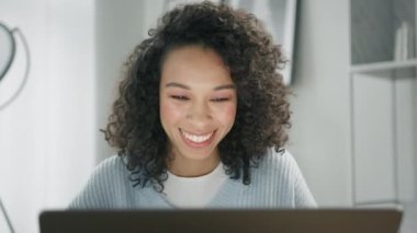Mutlu Afro-Amerikan iş kadını, öğretmen konferans görüntülü konuşmasında web kamerasına bakıyor. Gülümseyen iş kadını koçu gülüyor, Webinar, online sınıf, sanal toplantı sırasında dizüstü bilgisayara bakıyor. 