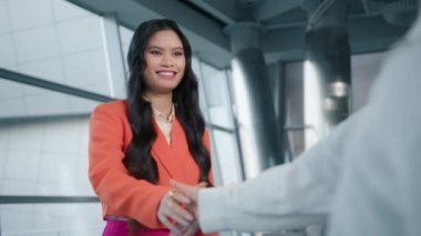 Mutlu Asyalı iş kadını açık gülümseme eşiyle tokalaşıyor. Lider ortaklık. İki mutlu iş ortağı yönetici yönetici el sıkışırken ofis toplantısı