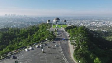 Griffith Park Gözlemevi binasının sinema yeşil çimlerinin üzerinde uçan güzel bir hava aracı. Arka planda güneşli bir yaz manzarası var. Los Angeles California ABD Mar 2023