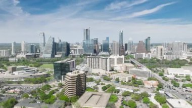 Austin şehir merkezinde manzaralı iş yeri binaları olan yeşil banliyö bölgesinde güneşli bir yaz günü Teksas 4K hava sahasında uçan insansız hava aracı. Austin gökdelen binaları Skyline video mavi gökyüzü