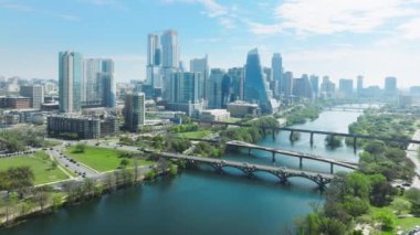 Austin Texas, Colorado nehir parklarının sinema arka planında şehir merkezi gökdelenleri olan insansız hava aracı görüntüleri. Finansal ve konut binaları güneşli yaz gününde şehir manzarası, 4K görüntüler ABD