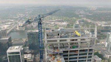 Austin Havayolları, ABD. İnşaat alanındaki vinç görüntüsü endüstriyel bölgede çalışıyor. Modern mimari geliştirme manzaralı Austin şehir merkezi manzaralı hareket arka planı 4K