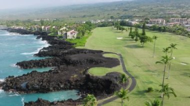 Volkanik tropik Büyük Ada 'da pahalı gayrimenkullerde yaşayan zengin insanlar Hawaii' de tatil 4K. Güzel manzara. Mavi okyanus ve yeşil golf sahası manzaralı pahalı yaz tatilleri.