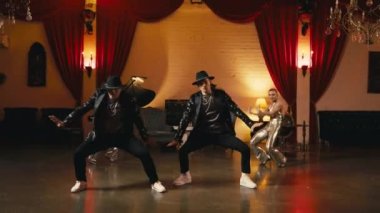 Profesyonel dansçıların Funk Show performansı. Çekici sanat deco gece kulübünde senkronize koreografi dansı yapan genç ve güzel insanlar. Parlak altın kostümlü dansçılar çiftler halinde dans ediyor.