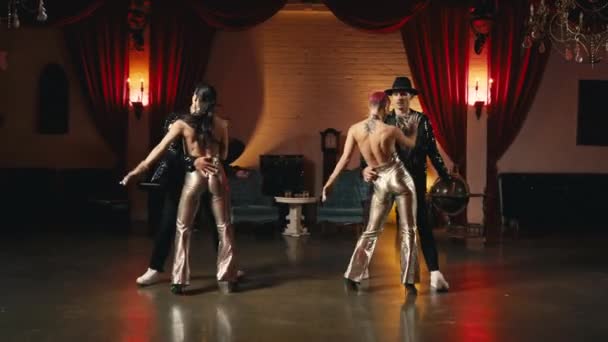 同期振付を動かすグループダンサー 黄金のスタイリッシュな服の面白い現代のプロのダンサーはスローモーション 華やかなファッションで印象的なショーパフォーマンス Golden Hollywood Style Night Club — ストック動画