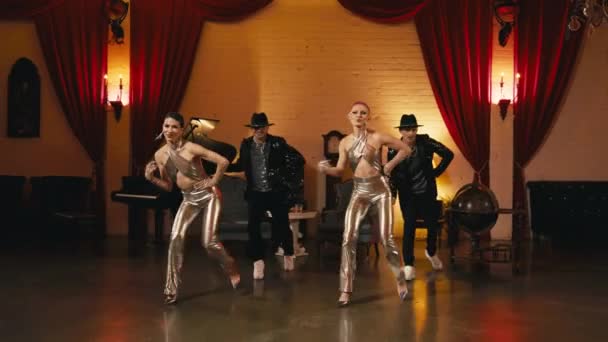 时髦的现代职业舞蹈家穿着金色时髦的衣服 动作缓慢 令人印象深刻的表演在迷人的时尚好莱坞风格的夜总会 团体舞蹈演员跳同步舞曲 — 图库视频影像