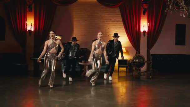 華やかなファッションで印象的なショーパフォーマンスゴールデンハリウッドスタイルのナイトクラブ 同期振付を動かすグループダンサー 黄金のスタイリッシュな服で面白い現代のプロのダンサースローモーション — ストック動画