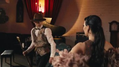 Eski moda gece kulübü atmosferinde el ele tutuşan tutkulu bir çift. Kadın tutan zarif adam etrafında dönüyor. Çekici aşıklar, şehvetli kadınlar seksi hareketler yaparken gözlerinin içine bakarlar.