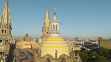 Guadalajara, Meksika 'daki ana katedralin renkli, parlak sarı ve beyaz kubbelerine yakın çekim. Guadalajara 'da altın gün doğumu ışığında tarihi eser havası. Sahne Mimarisi 4K