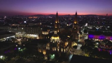Pembe günbatımında tarihi mimari katedralin üzerinde uçan drone. Guadalajara Meksika 'nın merkezi manzarası. Jalisco, Meksika 'da Guadalajara Katedrali ve Plaza Guadalajara Havayolları, 4K