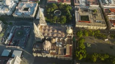 İHA, Guadalajara Meksika 'nın merkez meydanında hızla uçuyor. Gökdelenlerin yükseldiği şehir ile meydanın üzerinde güzel bir günbatımı. Plaza Guadalajara, gün ışığında Katedral manzaralı Meksika.