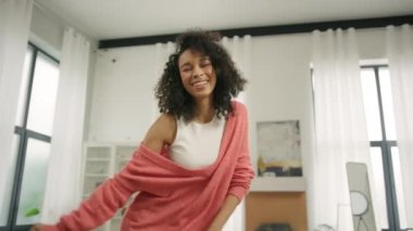 Gülümseyen blogcu Sosyal Medya makarası yapıyor. Genç Afrikalı Amerikalı kadın oturma odasında modern akıllı telefon kamerasıyla dans videosu kaydediyor. Şirin kıvırcık saçlı, müzikal içerik için dans eden kız öğrenci.