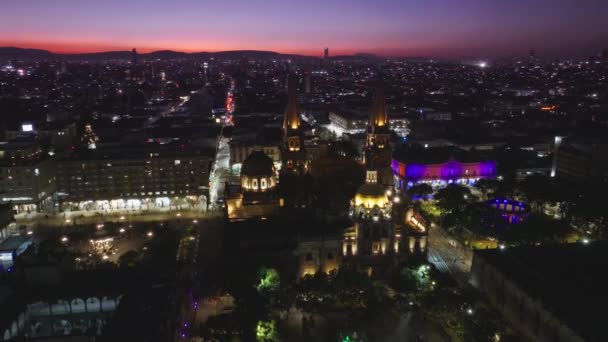 歴史的建造物大聖堂の上を飛ぶ無人機 グアダラハラメキシコの中央広場のピンクの夕日のオーバーヘッドビュー メキシコ ハリスコのグアダラハラ大聖堂とプラザ グアダラハラの空中写真 — ストック動画