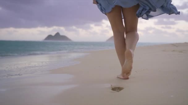 赤脚妇女走在风景秀丽的海滩上 在白沙滩上留下脚印 在美国夏威夷岛的暑假里 慢动作使女性游客的脚变得紧闭 穿着漂亮波浪裙的女人日出4K — 图库视频影像