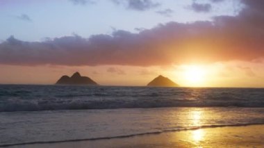 Lanikai sahilinde destansı gündoğumu, Oahu adası deniz manzarası güzel doğa. Hawaii seyahat konsepti, arka plan için sinema gülünün altın renginde doğuşu. Na Mokulua Adaları siluetleriyle Lanikai açıklarında
