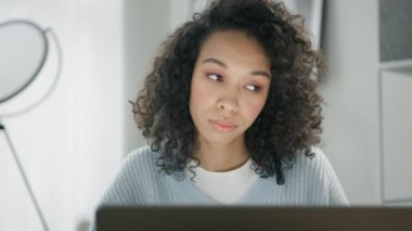 Genç konsantre olmuş iş kadını dizüstü bilgisayar ekranına bakıyor. Çevrimiçi projeleri analiz eden ya da dijital verileri finanse eden Afrikalı Amerikalı kadın girişimci. 4K görünümünü kapat