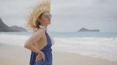 Plumeria orkideleri takan Hula kadını portresi. Mutlu gülümseyen Amerikalı kadın turistin mutlu yüzü güneşli yaz plajlarının tadını çıkarıyor Hawaii Oahu, ABD turizmi 4K ağır çekim