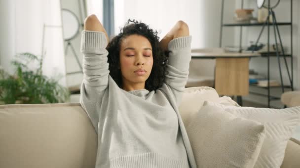 宁静迷人的年轻非洲裔美国女人手牵着手躺在沙发上 健康镇定的女孩躺在舒适的沙发上深吸一口气打盹感觉到家里没有压力4K — 图库视频影像