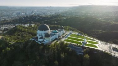 Griffith Gözlemevi Giriş Çim Gözlem Güvertesi 'nin etkileyici hava görüntüsü. Hollywood Dağı 'ndaki yeşil park güneşli yaz günbatımında mavi gökyüzünün altında. Los Angeles şehri Kaliforniya ABD Mart 2023
