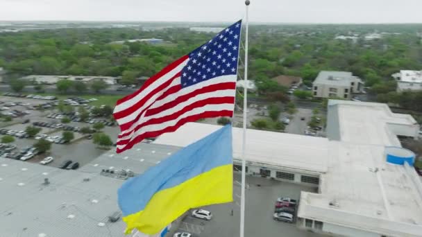 史诗般的创造性无人驾驶飞机飞行 美利坚合众国和乌克兰国旗周围的场景天线在空中摇曳 奥斯汀市背景 象征经济政治支持的两面旗帜 — 图库视频影像