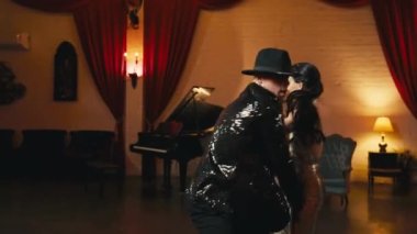 Klasik tiyatro içinde dans eden ince yapılı Asyalı güzel bir kadın. Göz kamaştırıcı çift akrobatik sicim hareketi yapıyor. Funk tarzı dans eden Asyalı profesyonel dansçı erkek 4K ile dans ediyor.