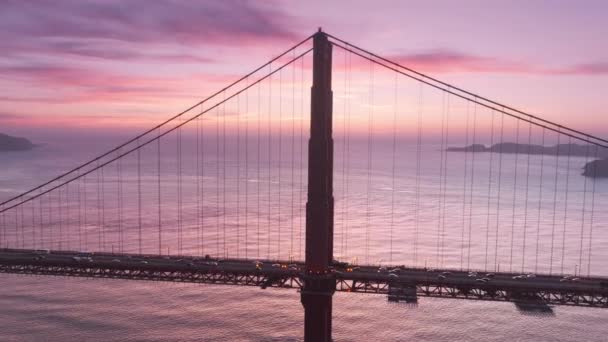 金门大桥的空中景观在史诗玫瑰紫色的天空背景 美丽的无人驾驶镜头红色悬索桥夜间照明在粉红的天空 旧金山的地标在电影日落上 — 图库视频影像