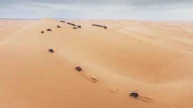 Hafta sonu Extreme spor açık hava hobisinin manzarası. Erkekler için spor eğlence konsepti 4K. Kum tepecikleri üzerinden hızla giden ATV arabasının hava manzarası. Kumullarda dört teker çekişli araç yarışması