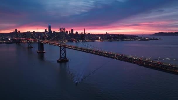 无人机拍摄的交通车辆驾驶穿过海湾大桥驶向旧金山市中心 旧金山商业大楼的轮廓 在远处可以看到夜间照明 — 图库视频影像
