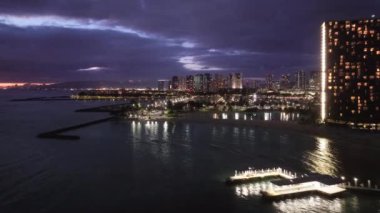 Hawaii Adası 4K 'da şehir ışıkları. Gün batımından sonra Waikiki sahilinde. Manzaralı Honolulu gökyüzü manzarası. Oahu şehrinin gece manzarası. Alacakaranlıkta sahil Bay City 'nin güzel şehir manzarası