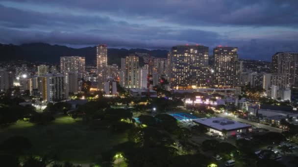 日没後にダウンタウンワイキキビーチ 風光明媚なホノルルスカイラインパノラマ 夜のシーンでオアフ市の空中ビュー 夕暮れ時の海岸ベイシティの美しい都市景観 ハワイ島のシティライト — ストック動画